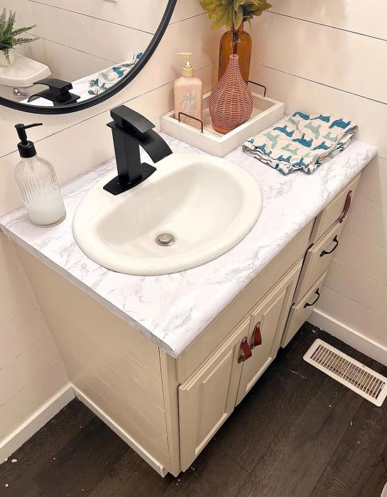 A bathroom sink counter adorned with the marble adhesive