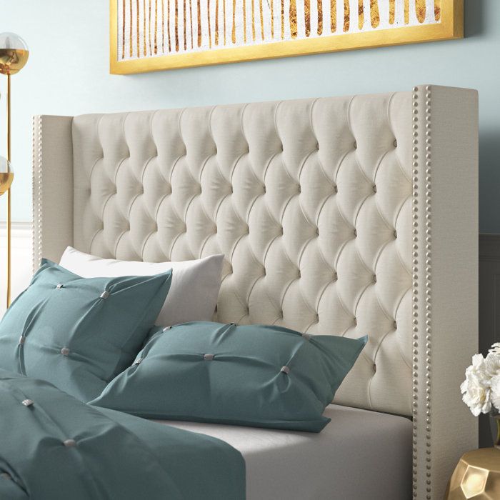 A luxurious upholstered bed with a tufted headboard, elegantly complemented by decorative throw pillows