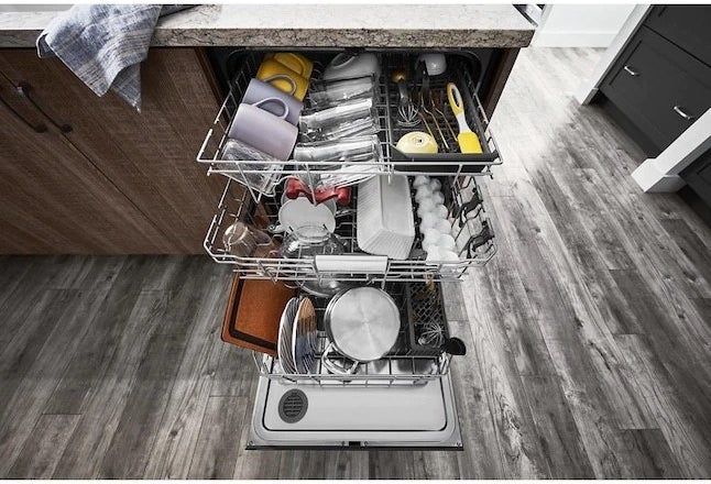 the dishwasher displayed with its three racks extended and filled with dishes