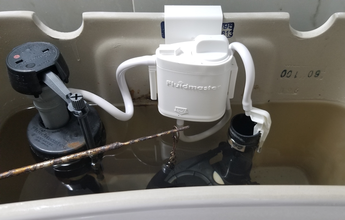 reviewer image of the flush 'n sparkle kit inside the water tank of the toilet