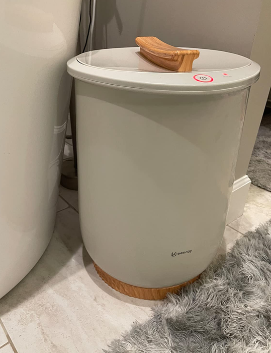 A photo from a reviewer showing the towel warmer resting on a bathroom floor