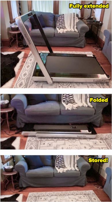 A reviewer demonstrates the treadmill neatly stored under the couch.