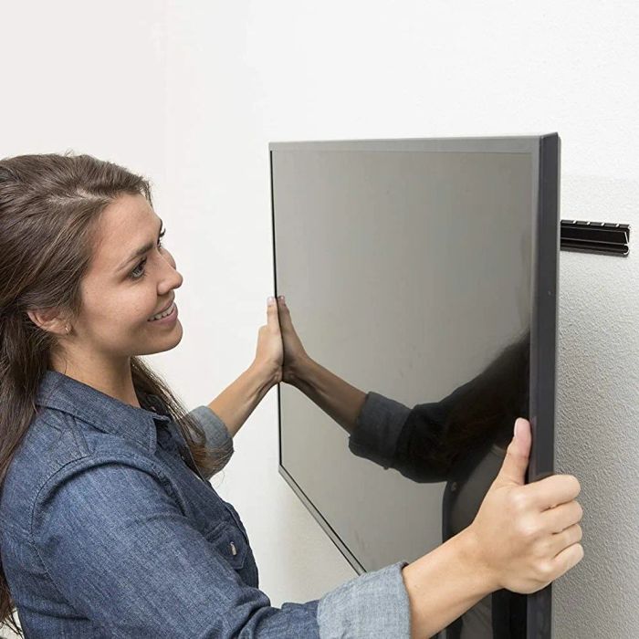 A person mounting a TV on the wall.