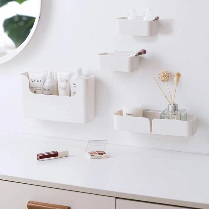 Four shelves of varying sizes are mounted on the wall, displaying a collection of bathroom essentials.