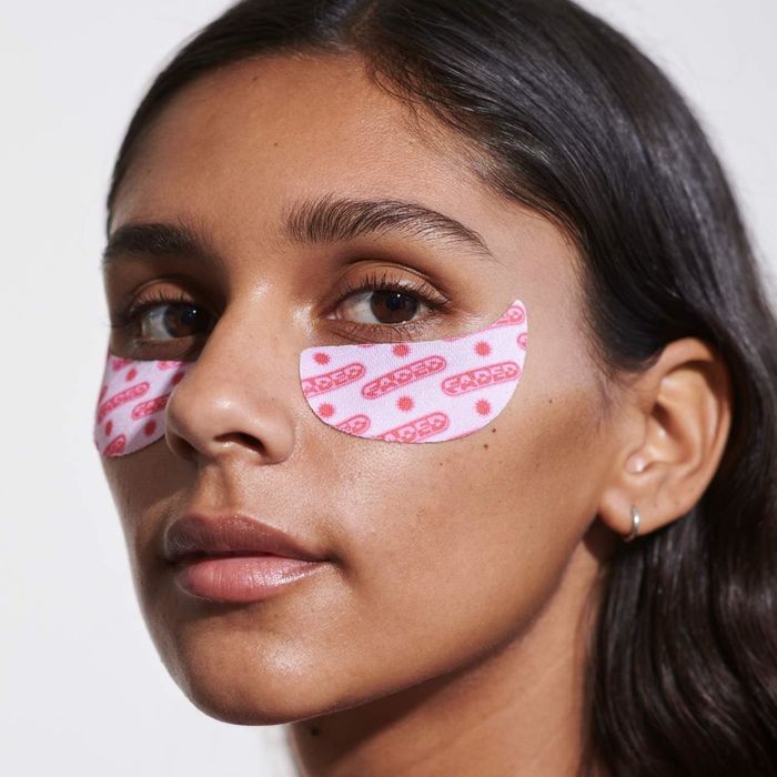 Model with under-eye patches featuring the brand logo