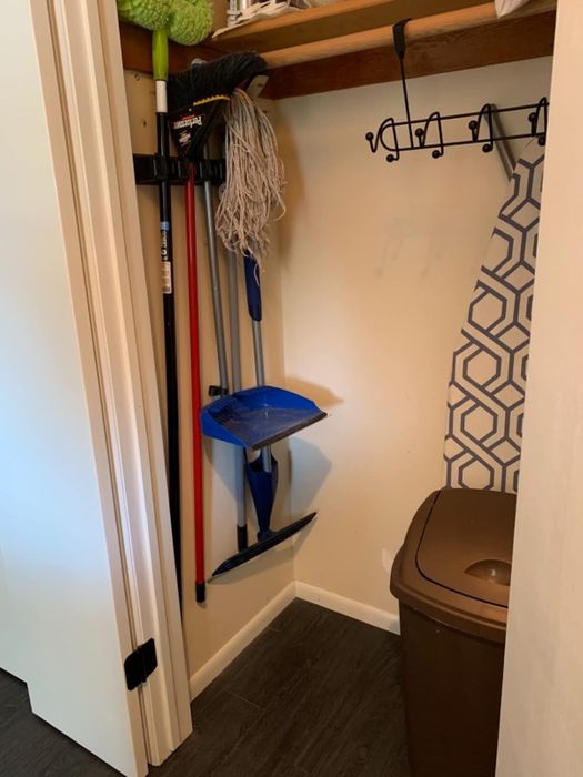The same reviewer demonstrating the space saved in the closet with the broom holder in place