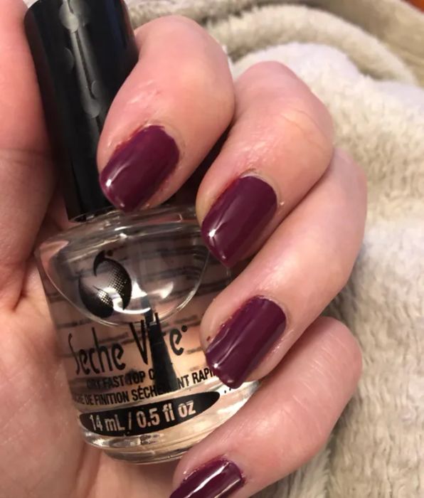 A reviewer holding a bottle of clear nail polish
