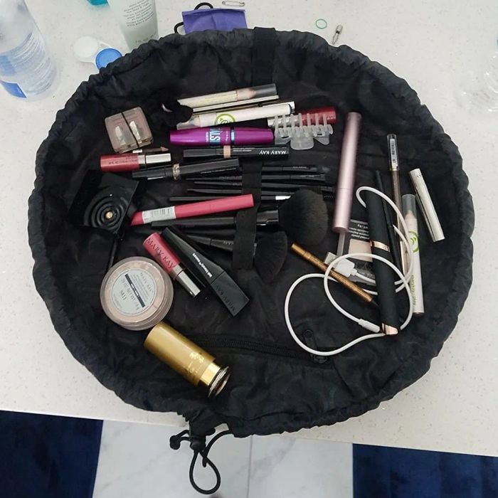 A photo of a reviewer with the makeup organizer fully opened, filled with various makeup items