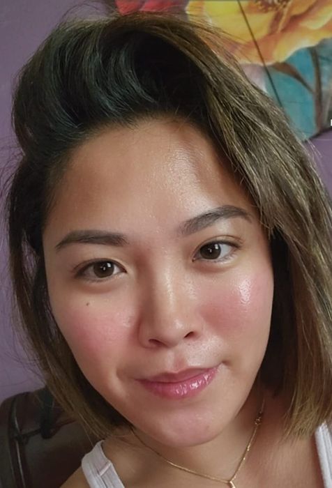 A reviewer with skin glowing after using the serum