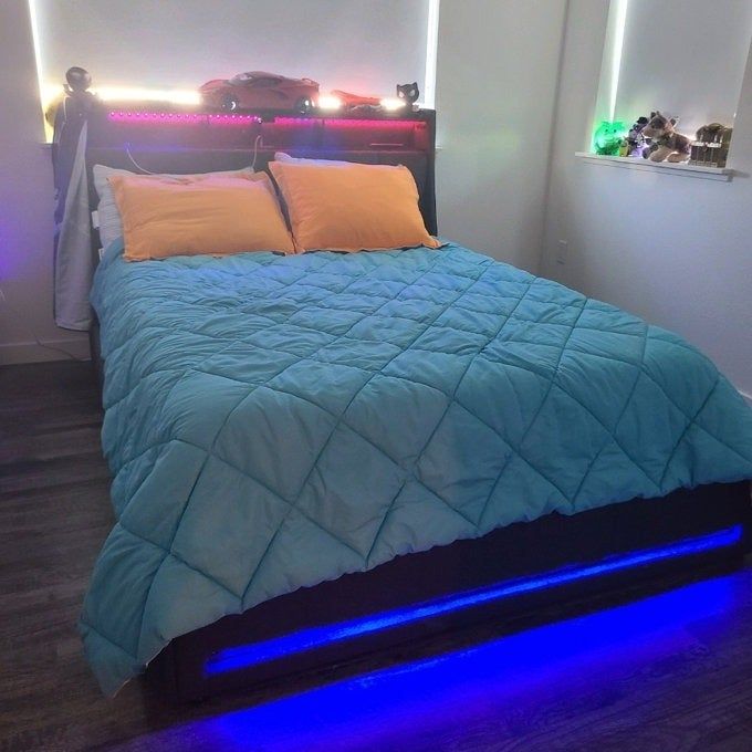 A modern bedroom with a bed that includes an illuminated headboard and base, highlighting the ambient LED lighting to create a stylish and cozy atmosphere