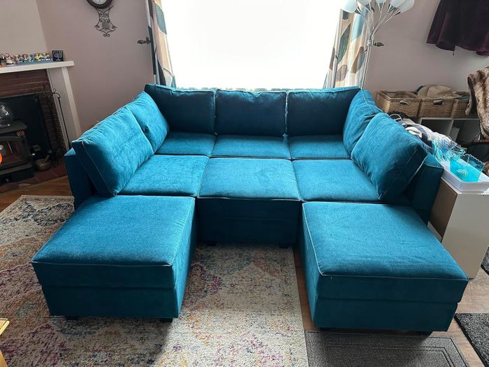 A modular sectional sofa with plush cushions and ottoman pieces, beautifully arranged in a living room setting.