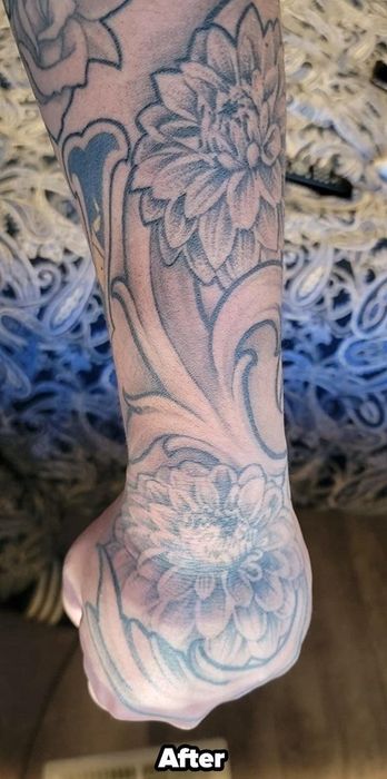 A reviewer showcasing the same arm tattoo after using the aftercare balm