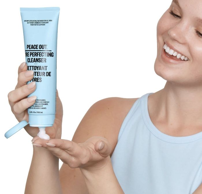 A model squeezing Peace Out Pore Perfecting Cleanser from a tube onto their hand.