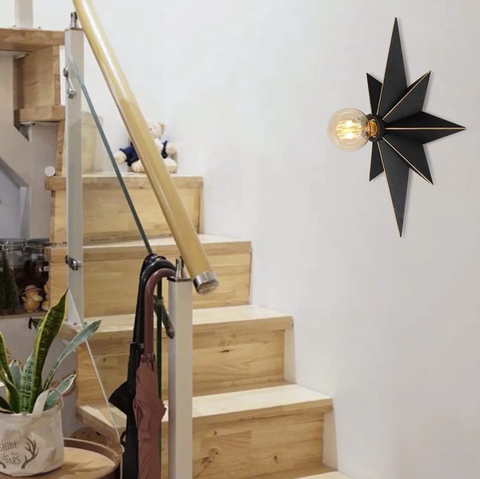 The black star light mounted on a wall, casting a stylish glow.