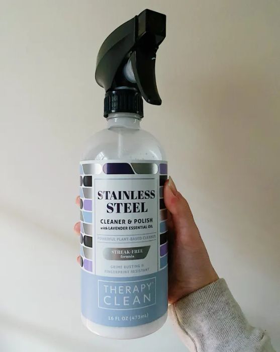 Mytourer holding a bottle of stainless steel cleaner, showcasing the product.