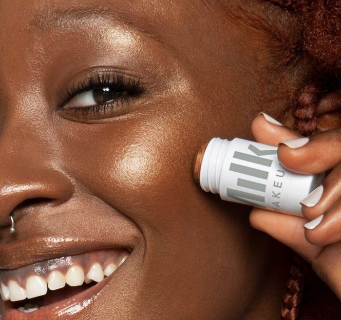 Person applying Milk Makeup Highlighter in Flash to their cheek