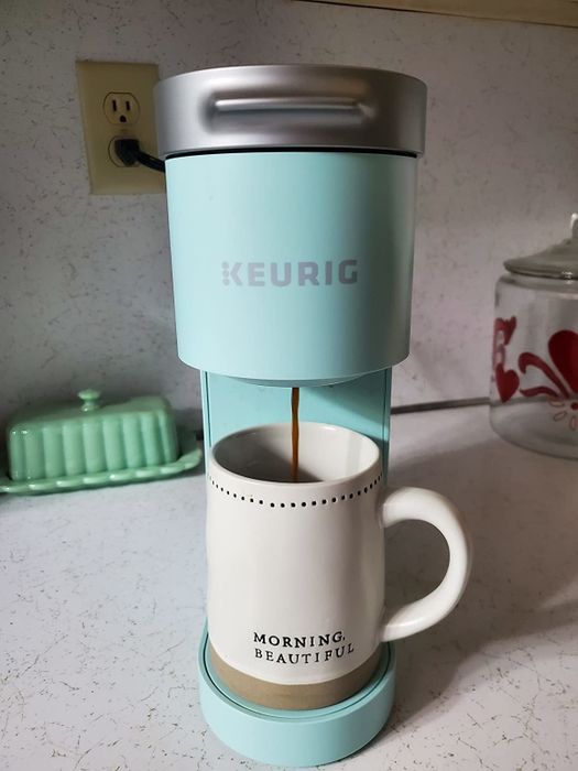 A reviewer shows the Keurig coffee maker in a light blue color.