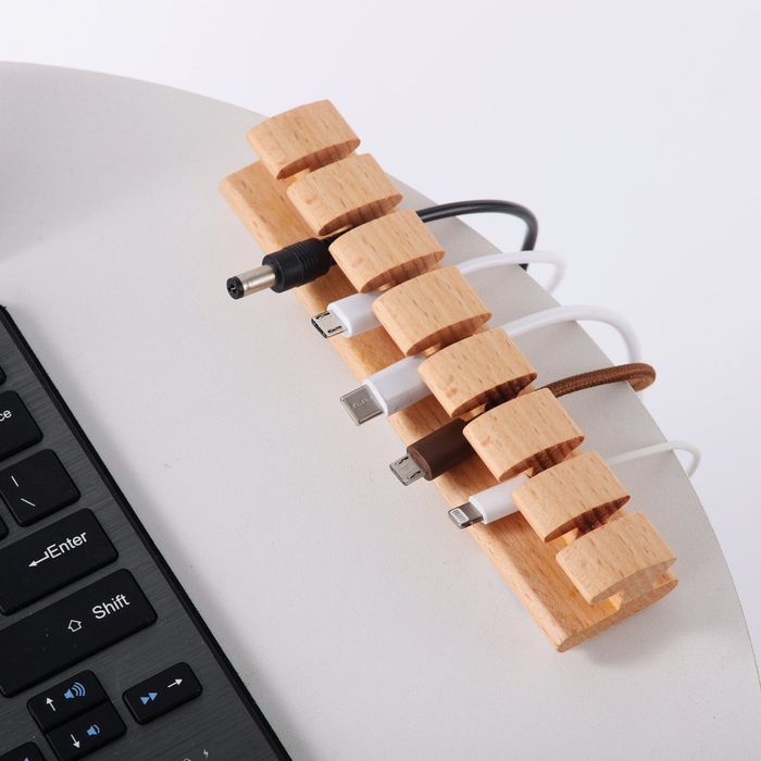 The light wood cord organizer neatly holding cords