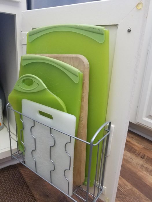 Reviewer using the cabinet shelf to neatly store various cutting boards