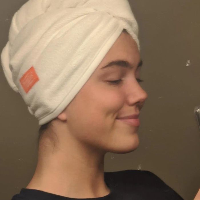 A reviewer wearing a white microfiber hair towel