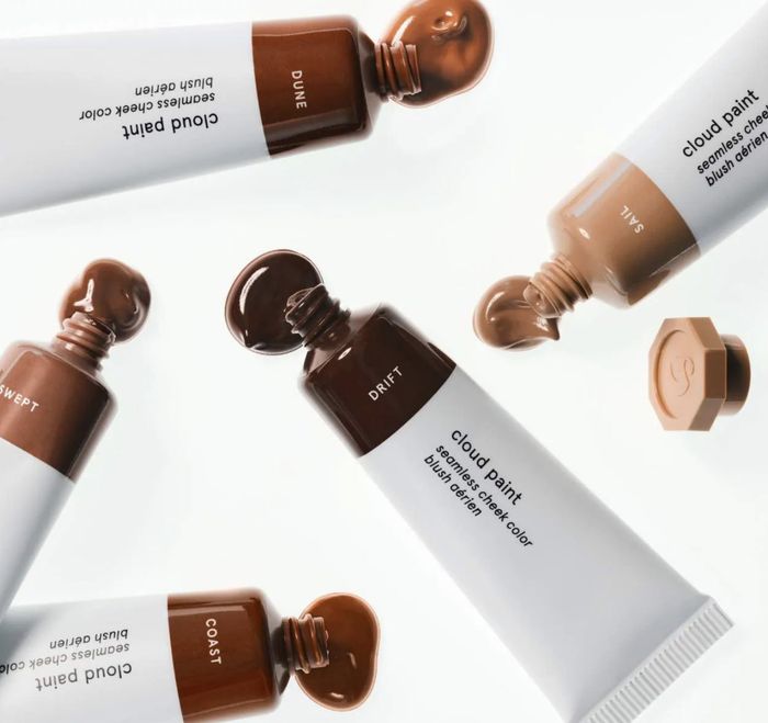 Tubes of Glossier Cloud Paint blush displayed alongside swatches of the product
