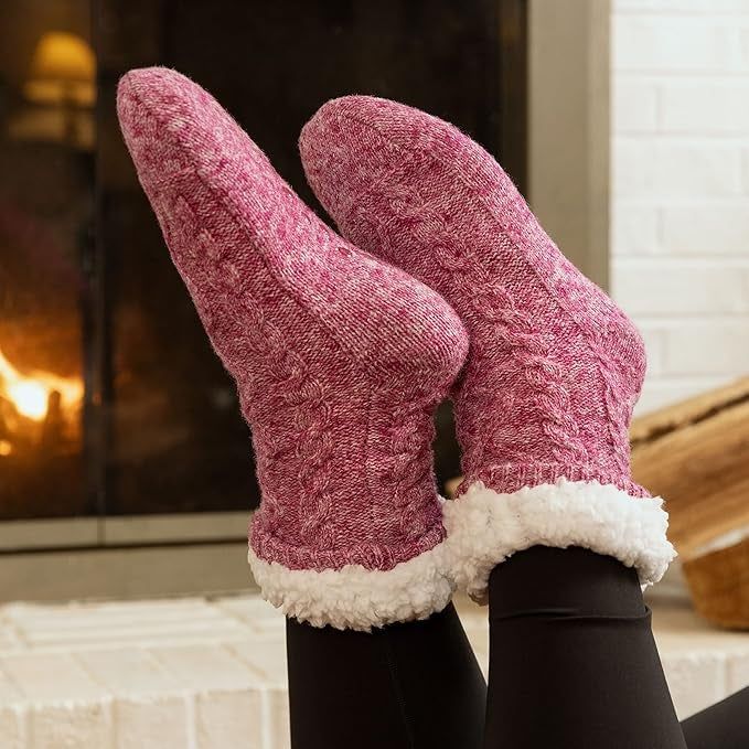 Warm, cozy feet in knitted socks with fluffy cuffs, resting by a fireplace, evoking a sense of relaxation—ideal for a winter shopping article.
