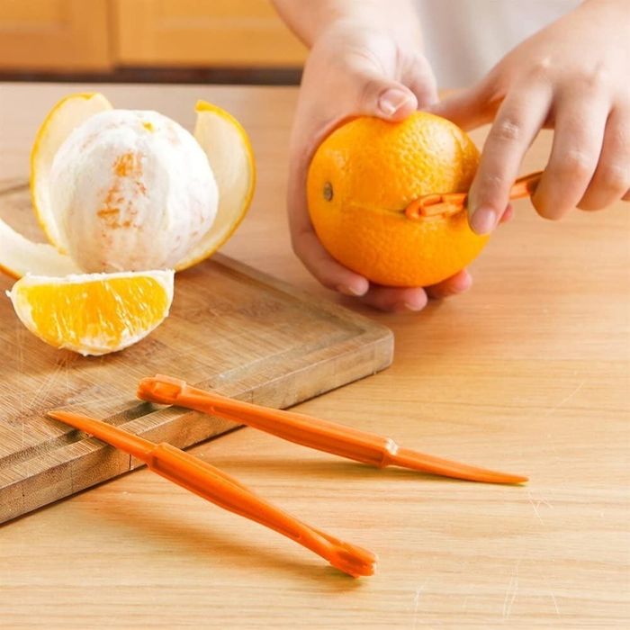 A hand demonstrates using the orange slicer to cut and peel an orange, showcasing its precision and ease of use.