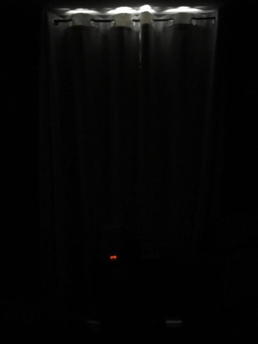 A reviewer's photo of a room darkened by Nicetown blackout curtains, creating a cozy ambiance.
