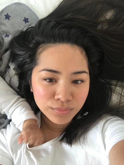 Person with a smooth complexion applying the face cream