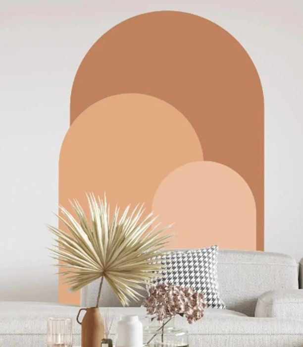 An orange and peach arch decal placed above a couch.