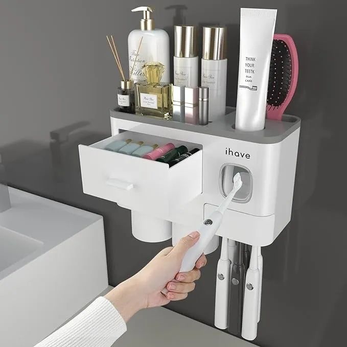 A wall-mounted organizer with various compartments for personal care products, with a hand reaching to pull out one of the drawers.