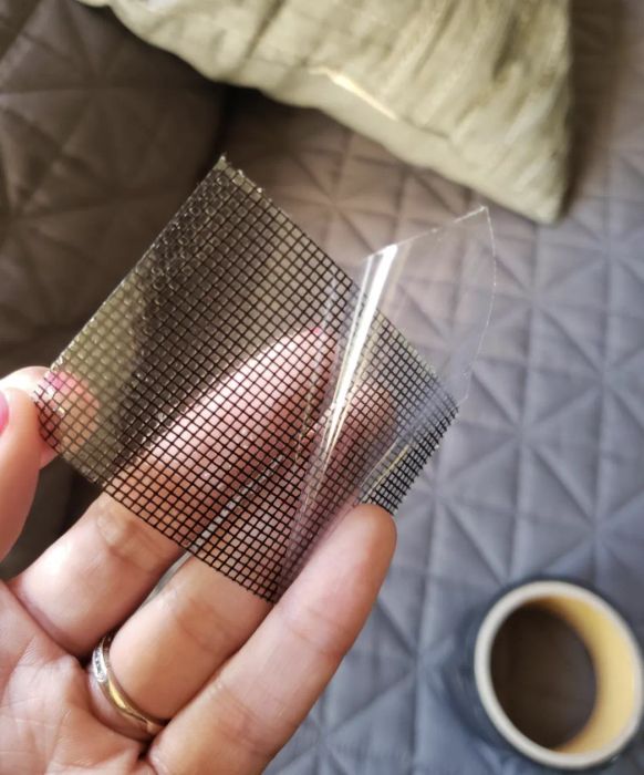 A customer review photo of them holding a piece of mesh repair tape, ready to use on their screen.