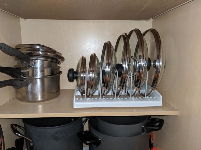 A reviewer shares a photo showcasing how their pot and pan lids are neatly arranged in the bakeware rack, making the kitchen more organized.