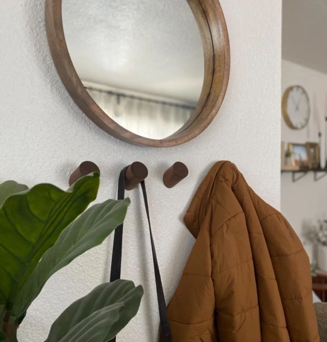 A reviewer's coat and purse hanging neatly on the black walnut wall hooks.