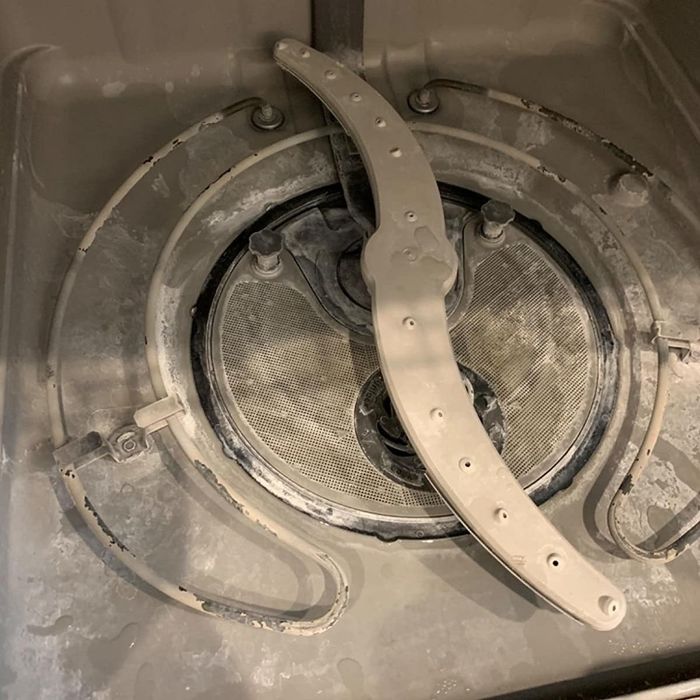 A reviewer shares a photo of their dishwasher covered in grime and buildup.