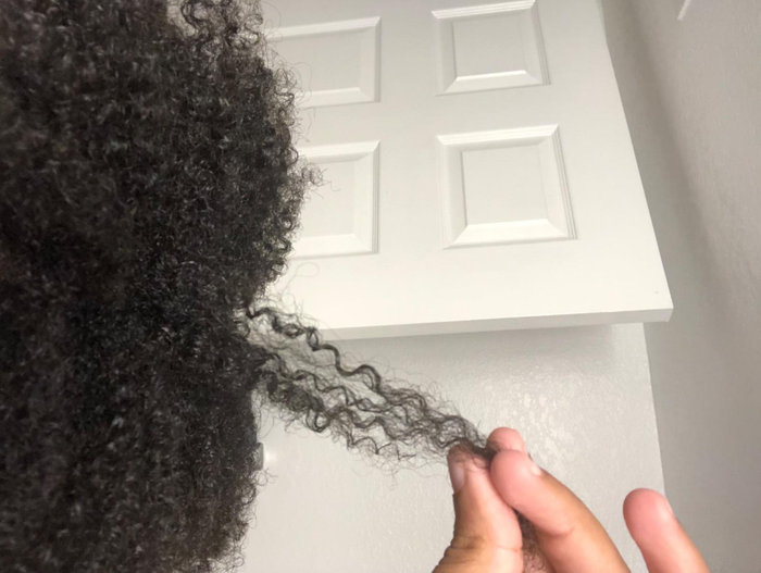 Reviewer showing off their healthy, curly hair