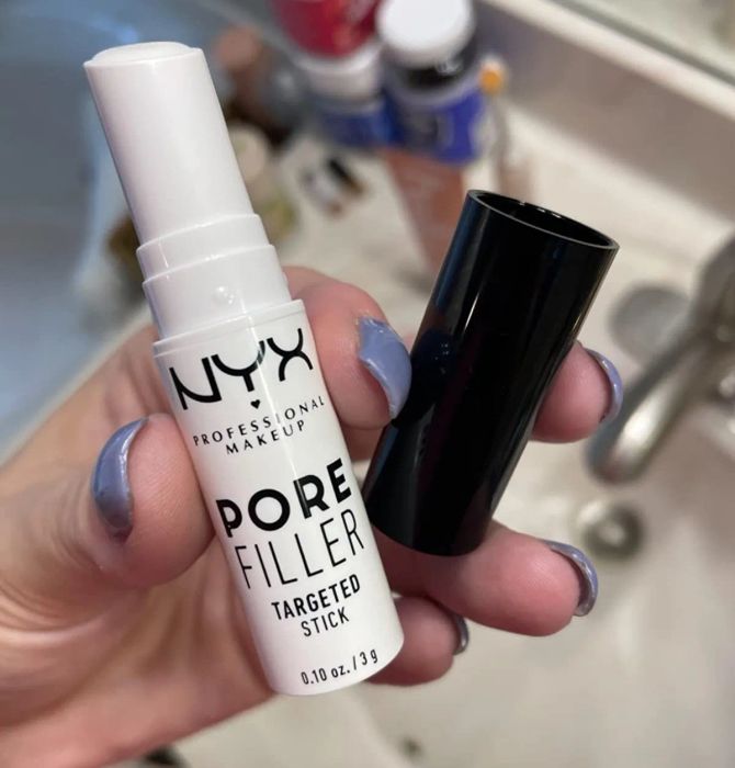 A different reviewer holding the pore filler stick.