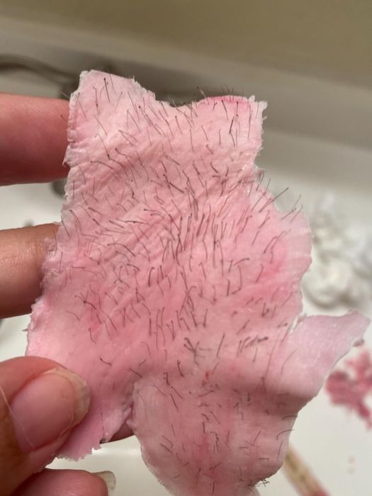 A wax strip covered in hair, showing the results after being used by the reviewer.