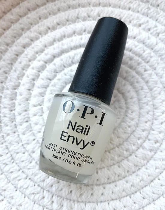 OPI Nail Envy nail strengthener bottle placed on a textured surface.
