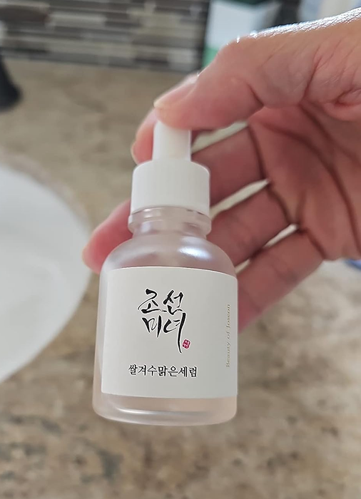 A reviewer holding up the serum bottle