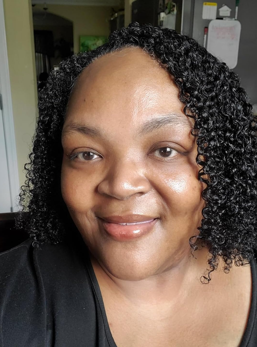 The reviewer flashing a smile with radiant, glowing skin.