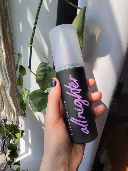 Hand holding the bottle of setting spray