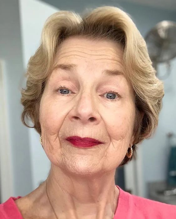 An older reviewer wearing a ruby-colored lip stain, showcasing a bold lip look.
