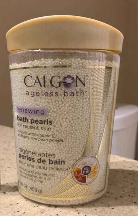 Calgon bath pearls and ChapStick total hydration lip balm are elegantly placed on a bathroom counter, adding a touch of luxury to your self-care routine.