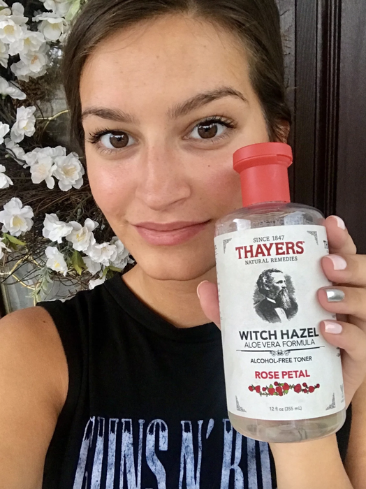 AnaMaria holding a bottle of toner up to her face.