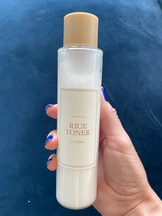 A reviewer holding up the toner bottle