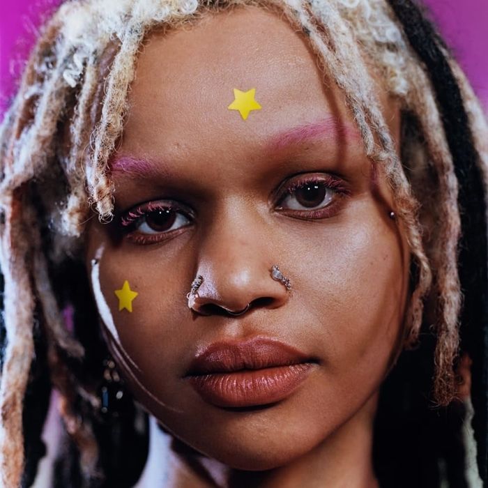 A person sporting star-shaped pimple patches across their face