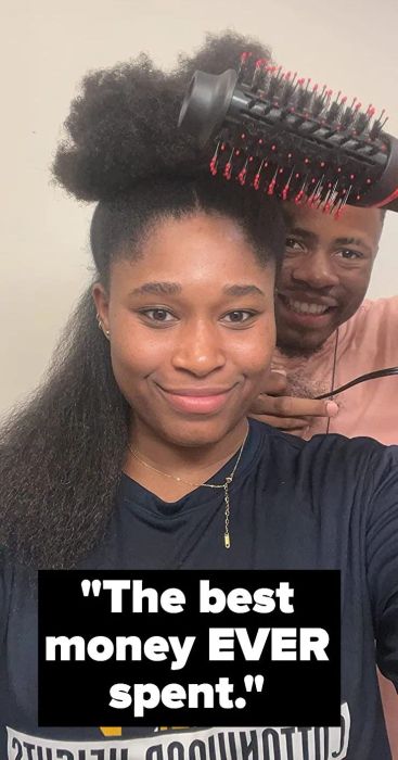 A reviewer showcasing their curly/coily hair that's partially blown out, with some text.