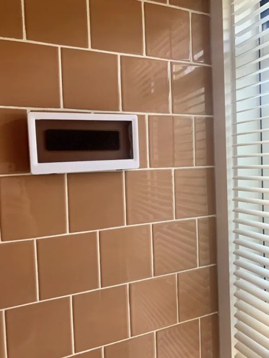 A reviewer's tile shower with the phone holder attached, ready for use.