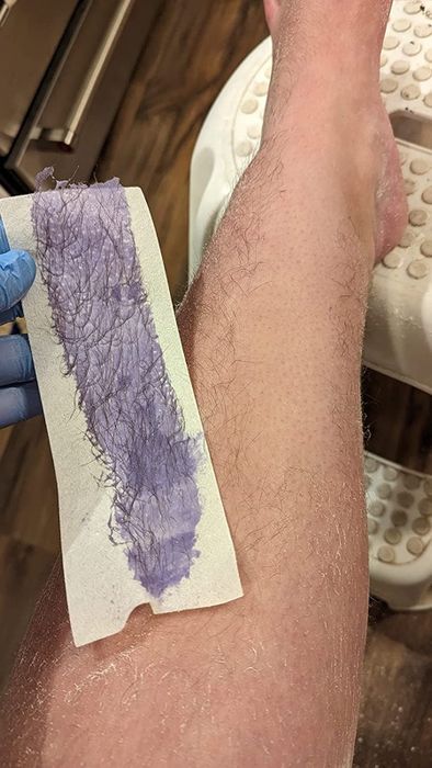 Reviewer showing off their smooth, waxed leg after using the waxing kit